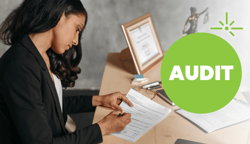 Mailchimp audit review with a woman analyzing documents at her desk.